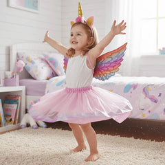 Child in unicorn costume with wings in a bedroom