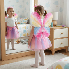 Child wearing a fairy costume with pink butterfly wings in a bedroom.